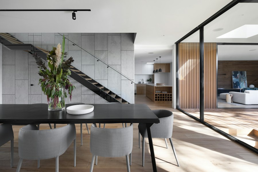 Interior de vivienda con escalera y cocina abierta, ejemplo de fotografía inmobiliaria.